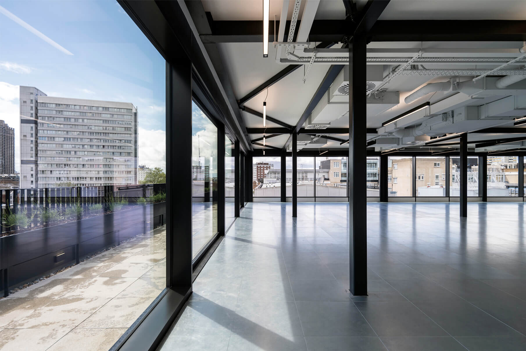 Fast-paced contemporary CAT A fitout with exposed concrete soffits at 44 Featherstone Road, London.