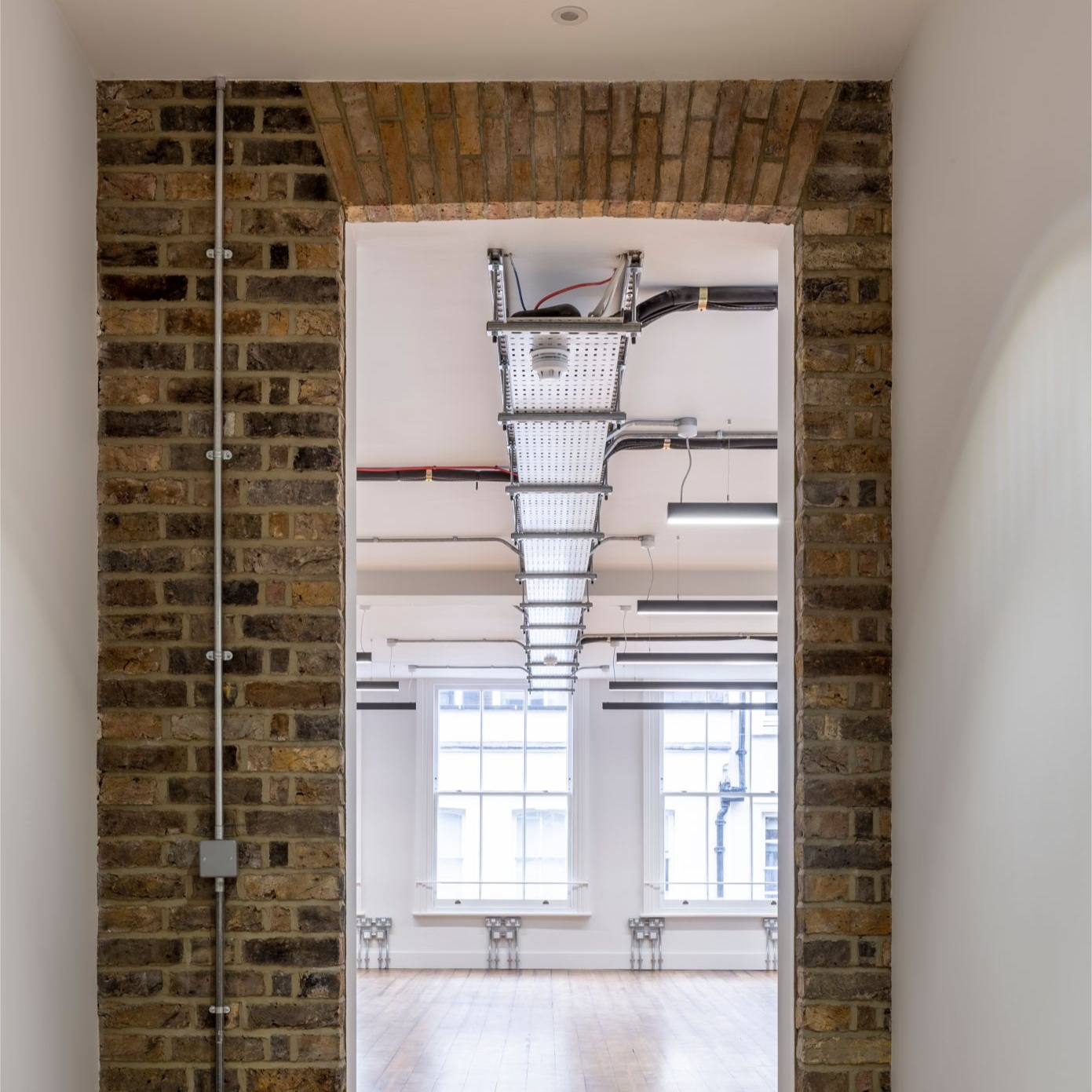 Suspended-office-lighting-through-brick-doorway