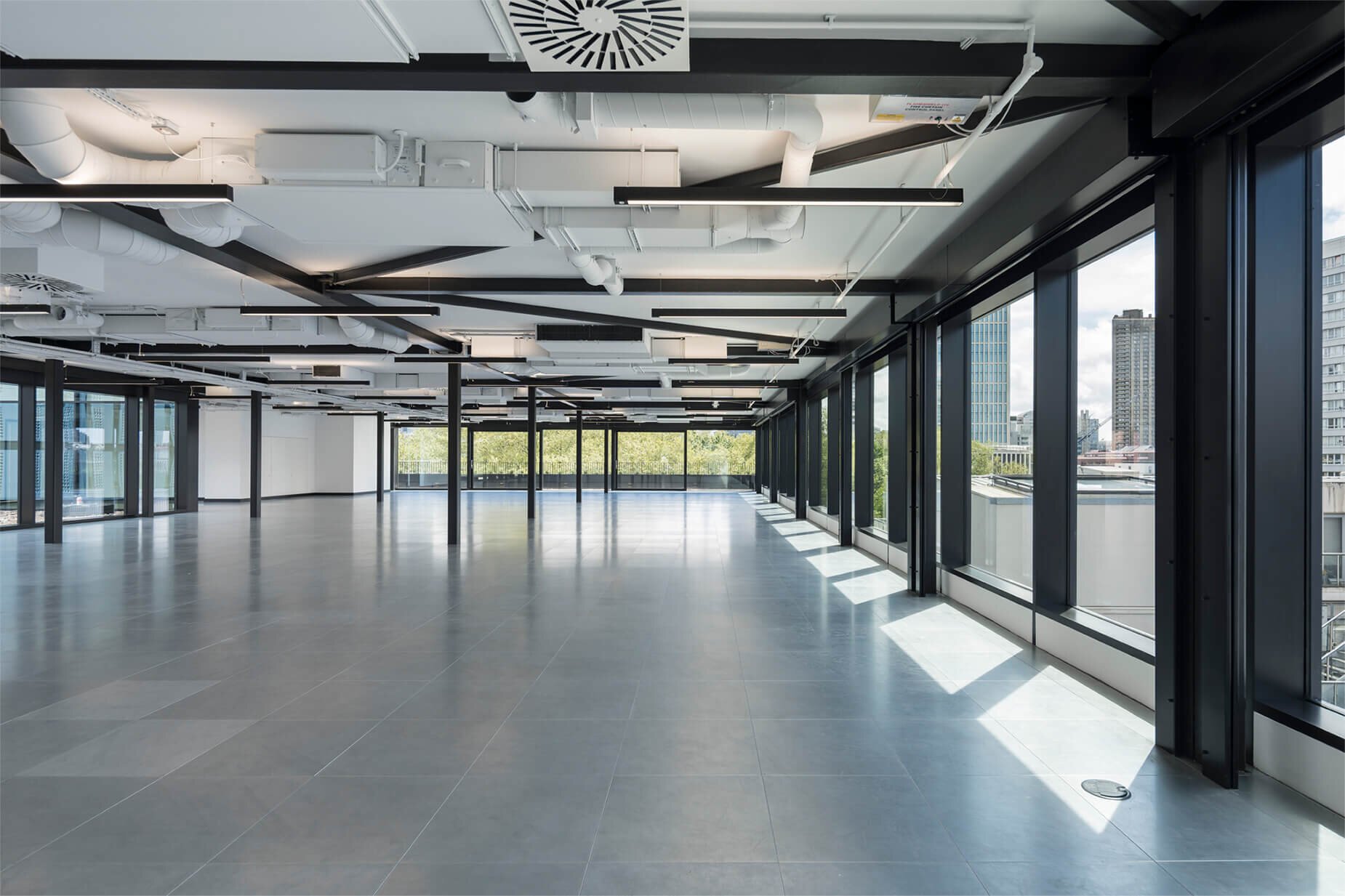 Fast-paced contemporary CAT A fitout with exposed concrete soffits at 44 Featherstone Road, London.